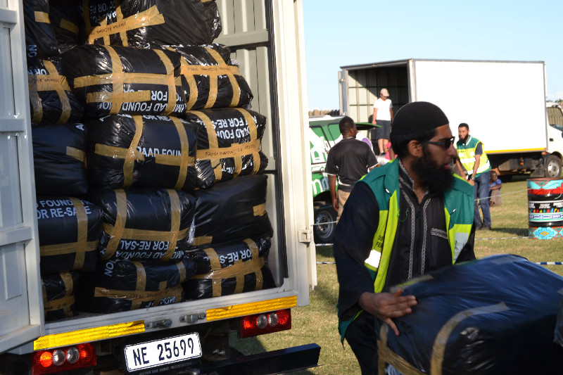 Packs of blankets are unloaded from the Al-Imdaad Foundation vehicle ahead of the afternoons distribution